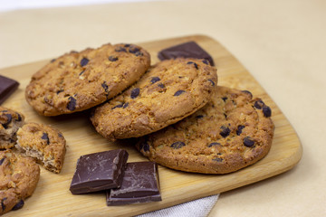 Freshly baked American chocolate chip cookies on rustic brown wooden table background