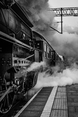 Old vintage train locomotive making steam starting from railway station