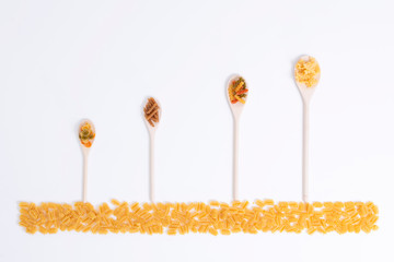 Assorted wooden spoons with a variety of pasta