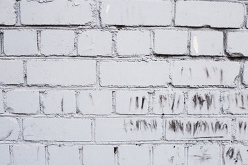  Fragment of a white brick wall with traces of aging and peeling paint