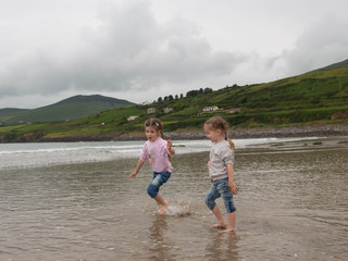 Children play on the coast of the Atlantic Ocean, family holidays in Ireland, Inch Beach, County Kerry Ireland