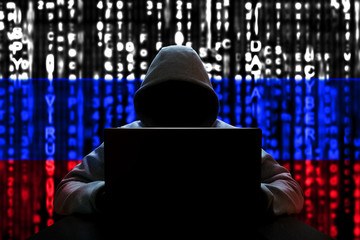 Cyber threat from Russia. Russian hacker at the computer, on a background of binary code, the...