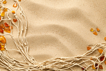 Fototapeta na wymiar Sand Background With Ambers And Fishing Net