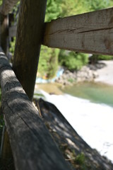 Blick durch Holzgeländer auf Strand mit Wasser