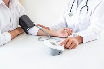 Doctor using Blood pressure monitor and stethoscope checking measuring arterial blood pressure on...