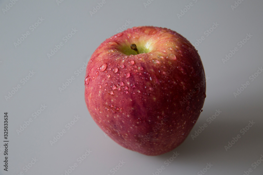 Wall mural  Ripe red apple on the table. There are drops of water on an apple.