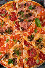 Different slices of pizza on wooden board on the table
