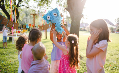 Fototapeta premium Small children with kite outdoors in garden in summer, playing.