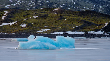 Iceland: blue iceberg in the middle of a frozen lake