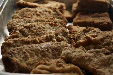 homemade breaded pork schnitzel in a castronrom pan container