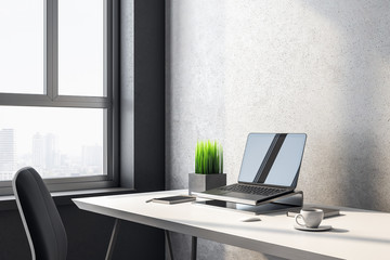 Laptop on designer workplace with blank screen