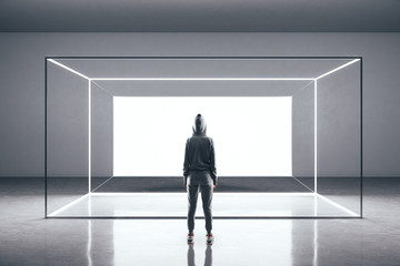 Hacker standing in futuristic gallery interior with glowing billboard