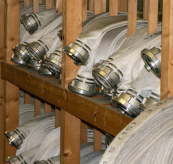 Weiße Feuerwehrrollschläuche im Regal