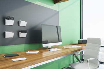 Naklejka premium Contemporary green workplace with сomputer on table