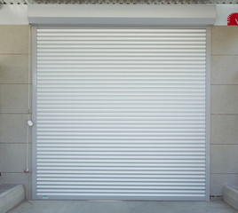 Shutter door or roller door and concrete floor outside .White Automatic shutters in a house . gates in the garage . Automatic Electric Roll-up Gate Or Push-up Door In  Building Ground Floor .