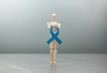 Wooden figure with blue prostate cancer ribbon