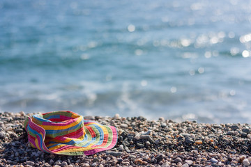 Colorful beach hat on a pabble beach 