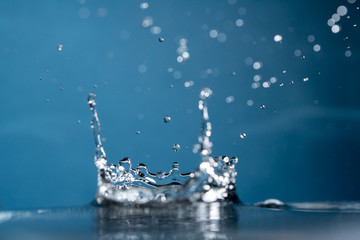 Fototapeta na wymiar Water Drop falling making droplet splash and waves clean and fresh symbol.