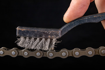 Bicycle chain and metal brush for cleaning dirt. Care of the bicycle's drive system.