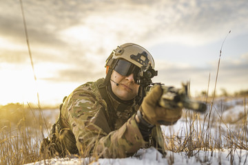 Ukrainian soldier lies in shelter and aims in the enemy. War of Russia and Ukraine. modern warfare battlefield