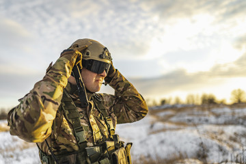 military army man soldier corrects his helmet. full equipment commandos with helmet and weapon gun....