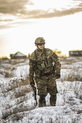 equipped army soldier Man in the winter multicam camouflage is patrolling or patrol field...