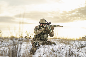 Modern Ukrainian soldier in multicam camouflage is lying and aiming aim at the sight. full...