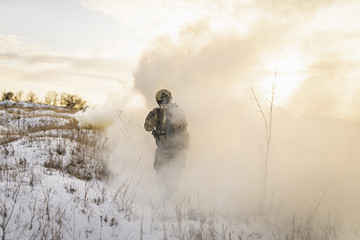Ukraine vs Russia war conflict. Ukrainian soldier army man running through the smoke and explosions sun backlight and smoke background.atmosphere of battle. commandos on the winter battlefield