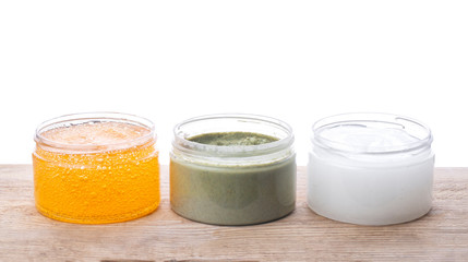 Set of cans of cream of various colors on wooden background