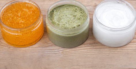 Set of cans of cream of various colors on wooden background