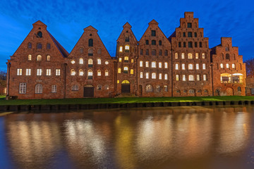 Naklejka premium Historische Salzspeicher in der Altstadt von Lübeck an der Trave bei Nacht. Mit Spiegelung im Wasser.