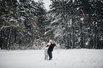 Couple playing with snow in the forest