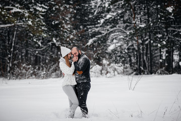 Couple playing with snow in the forest