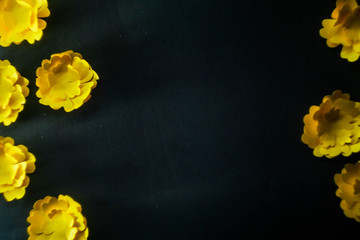 Yellow paper flowers on black background. Spring floral concept. Copy space 