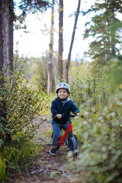 Young boy looks up happily while riding his bike
