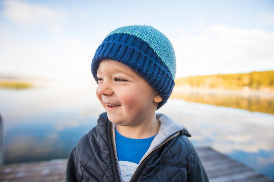Portrait of young boy laughing on dock.