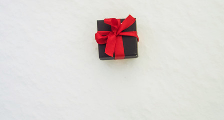 Isolated Black gift box with red ribbon. Copy space. Winter holidays sale