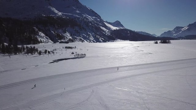 deux skieurs sur le lac gel&eacute; par beau temps - Suisse