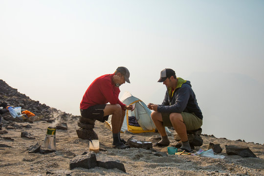 climbers playing cards at camp while waiting for weather to clear.