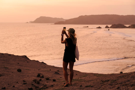 Young woman at coast at sunset