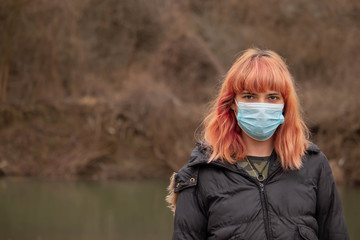 Girl with mask to protect her from Corona virus. Corona virus pandemic. Woman with mask with COVID 19 written.Beautiful girl with medical mask. People are hospitalized for prevention. Coronavirus.
