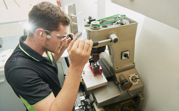 Locksmith working on the duplicate of a key in the duplicating machine