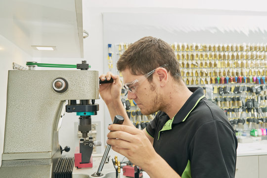 Locksmith working on the duplicate of a key in the duplicating machine