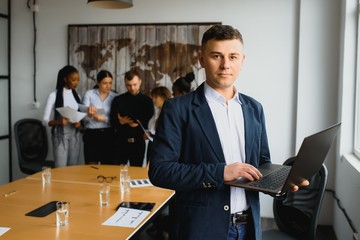 Multiethnic startup business team on meeting in modern bright office interior brainstorming, working on laptop and tablet computer