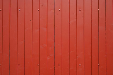 wooden wall of red wood house made of plank boards vertically Background Texture