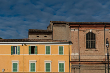 Fototapeta na wymiar yellow building with green shutters on main sqaure Piazza della Liberta in Bagnacavallo, Italy