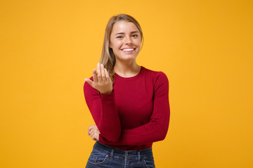 Smiling young blonde woman girl in casual clothes posing isolated on yellow orange background in studio. People lifestyle concept. Mock up copy space. Doing calling gesture like says come here to me. - obrazy, fototapety, plakaty