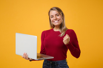 Smiling young blonde woman girl in casual clothes posing isolated on yellow orange background in...
