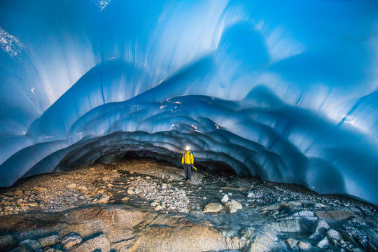 Mountaineer standing in glacial cave.
