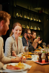 Group of best friends sitting in restaurant, having dinner, drinking wine and having fun.